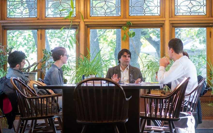 Philosophy professor talking at table with students