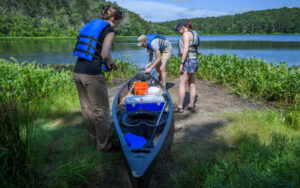 Global Environmental students loading up canoe to go on lake for samples