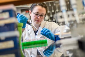 A student working in a chemistry lab, courses needed for a biotechnology degree