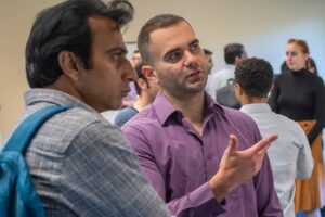 students discussing economics at a poster session