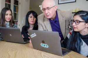 faculty and students review work on the computer