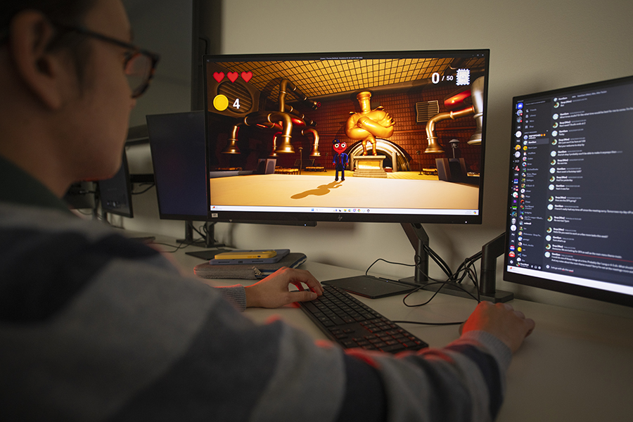 interactive media - student behind computer creating an interactive game design