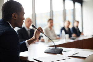 A person seated near a microphone engaged in debate