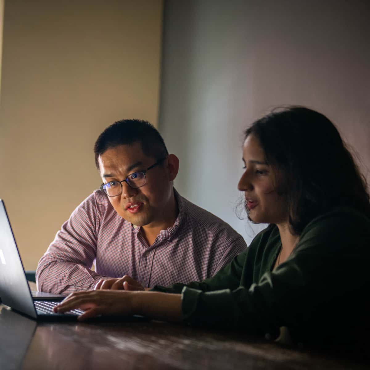 Shuo Niu works with a student at the computer