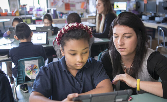 Student studying in classroom with student teacher