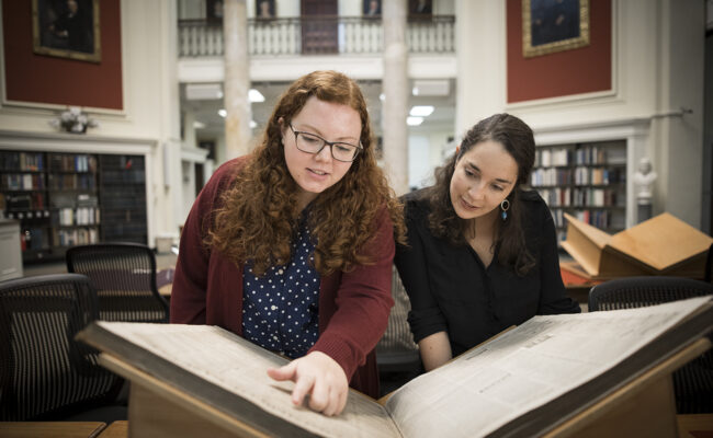 Students looking at old book