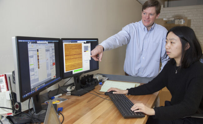 Michael Boyer working with graduate student in physics lab
