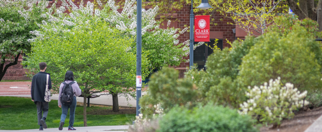 Two graduate students walking side by side on Clark campus