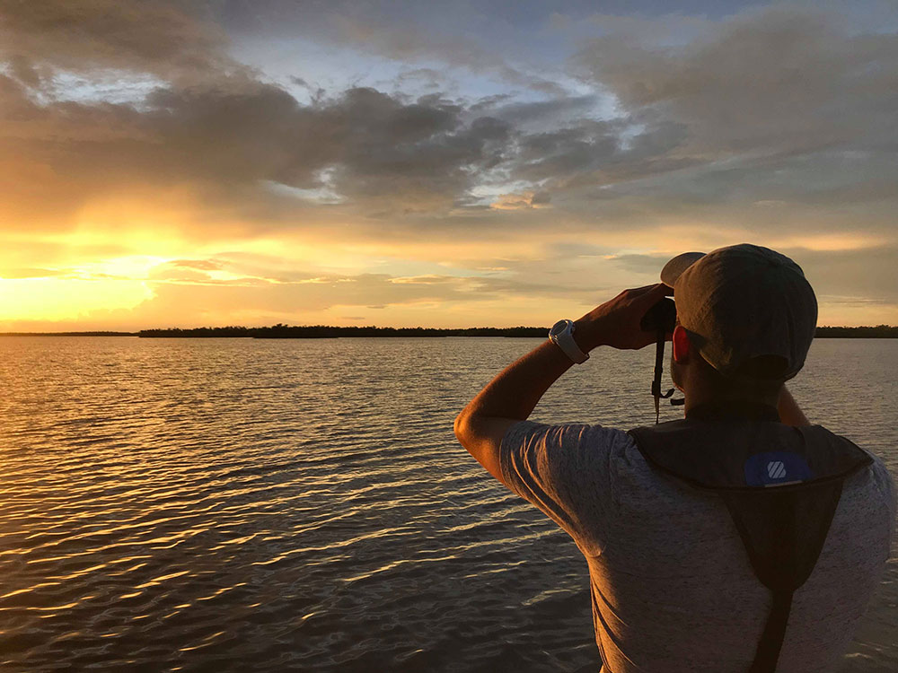Anthony Himmelberger surveying the ocean with a pair of binoculars during an internship