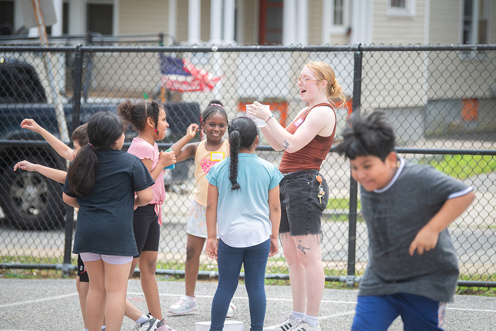 Clark education student interacting with students on the playground at Woodland Academy