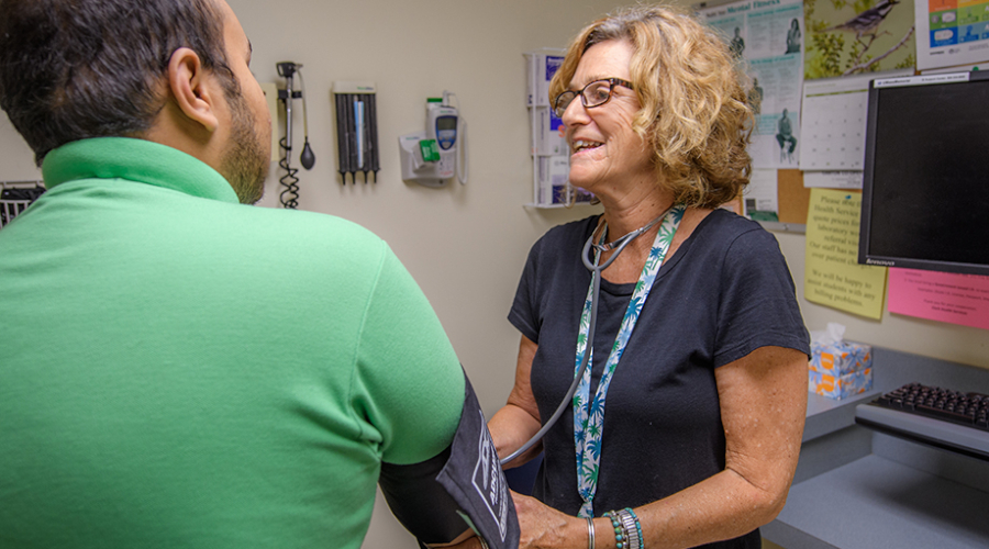 Nurse with patient checking blood pressure
