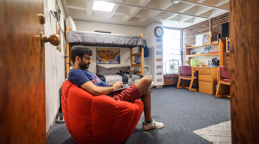 Student sitting on beanbag chair in dorm room