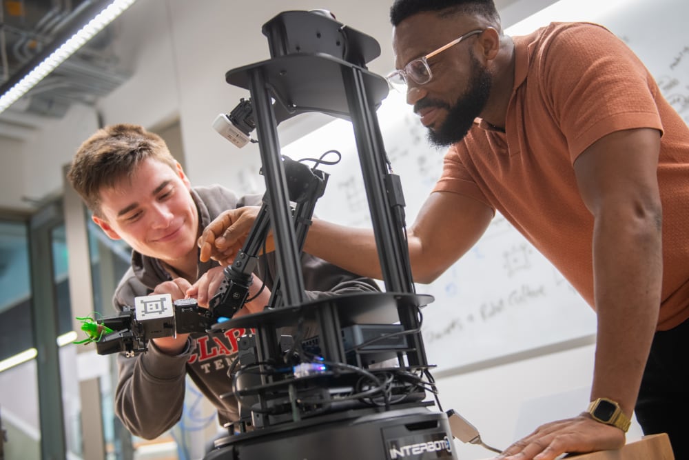 Adrian Ramirez ’25 and Richard Geli, M.S. ’25, work in the robotics lab.