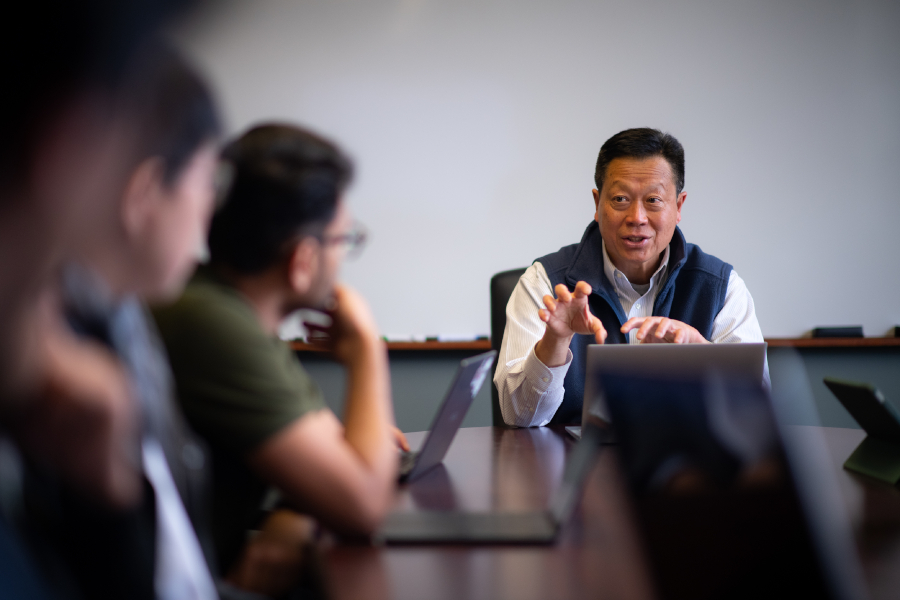 Graduate students in classroom looking intently at professor