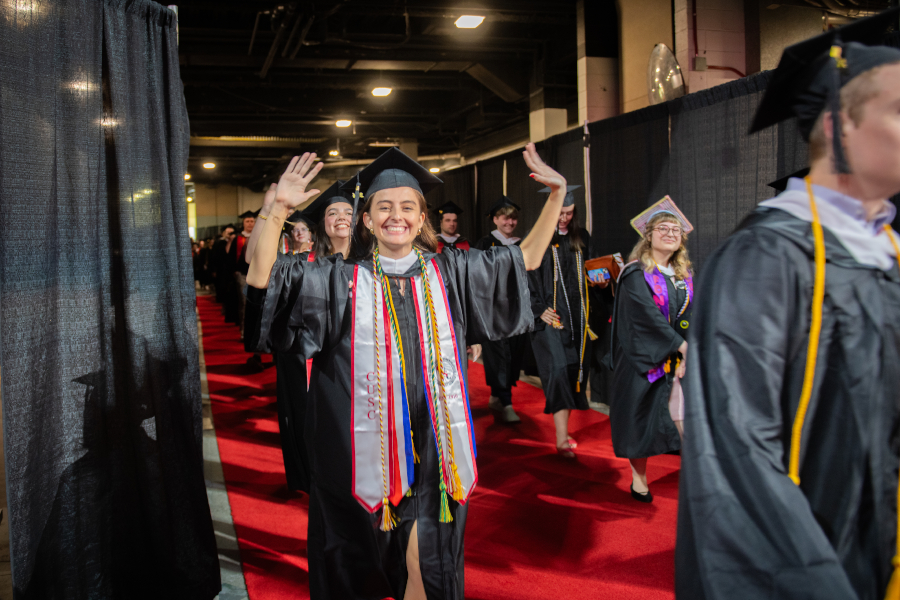 Student raising hands up at commencement cerermony