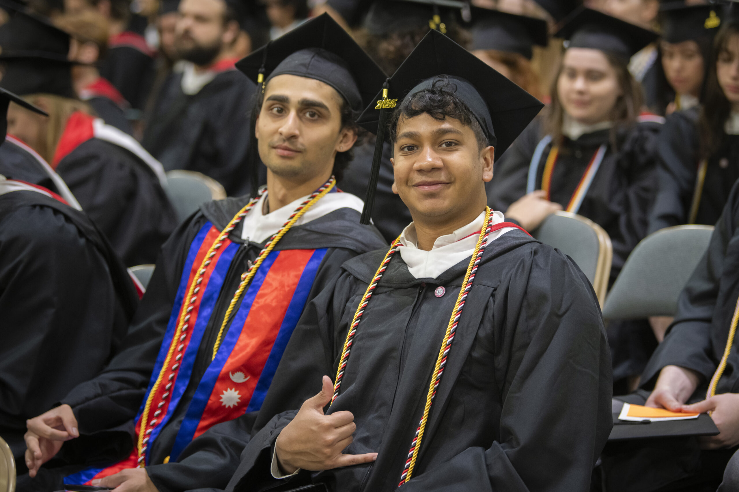 Two students seated at the 2025 Commencement ceremony