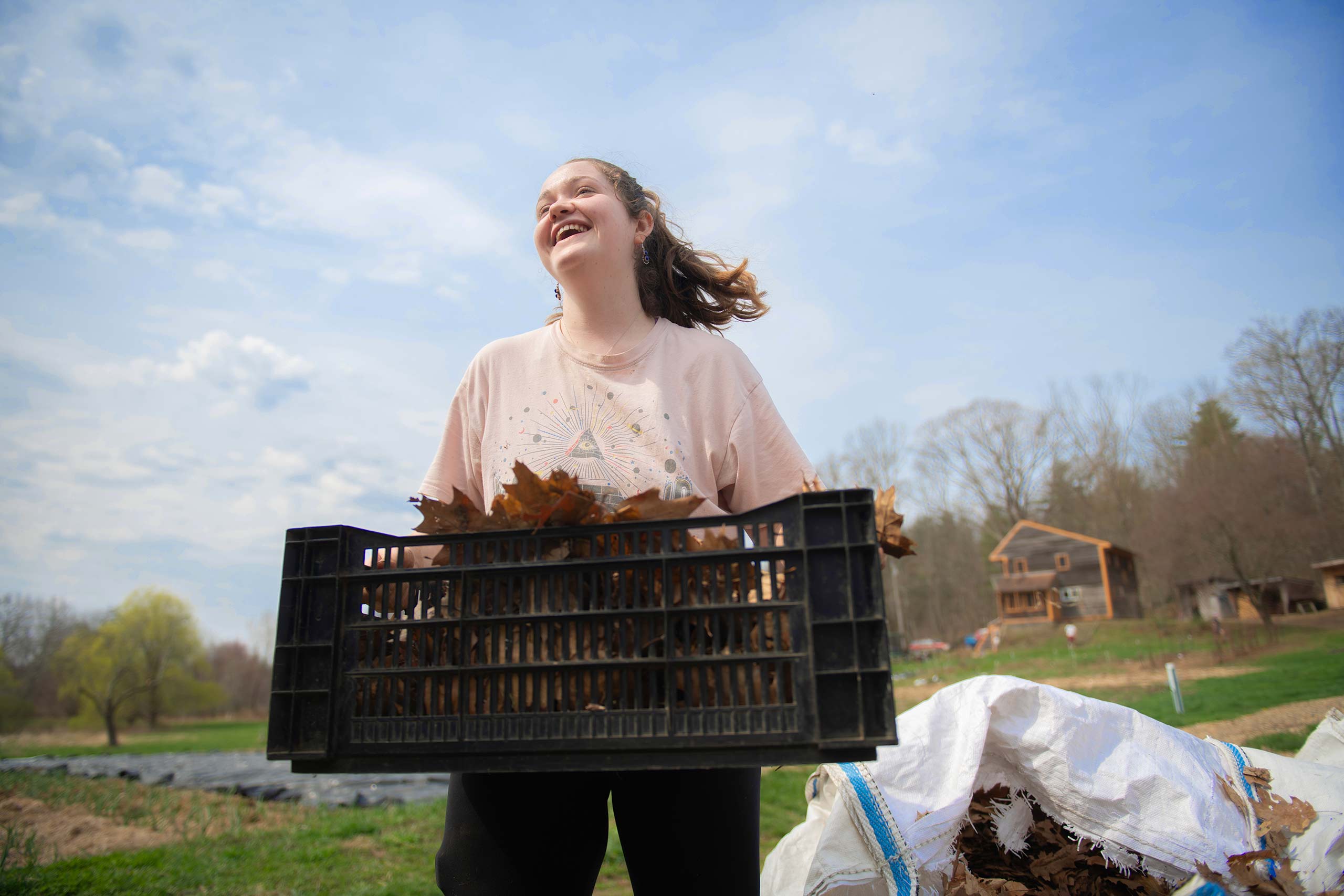 A student carries produce at a local farm during a working visit to a local farm for a course on food production.